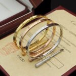 A Cartier narrow bracelet with a sleek and elegant design, featuring a gold finish and subtle engravings.